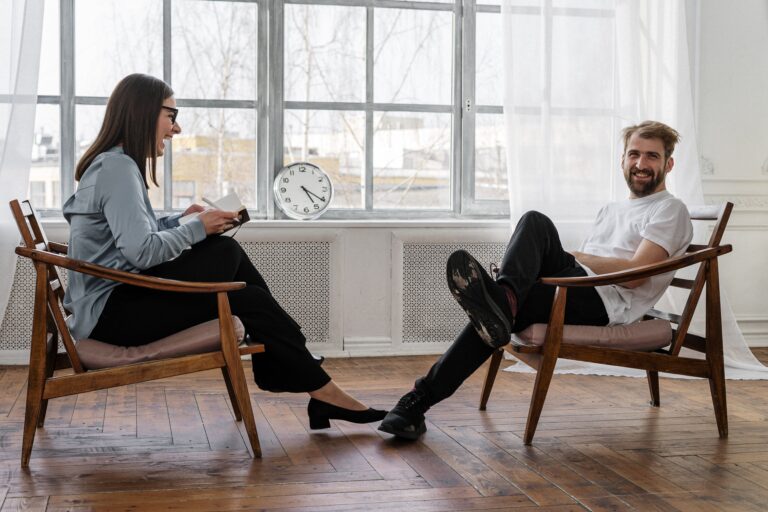 Two people siting on the chair and talking with each other