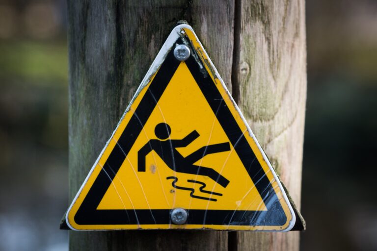 yellow triangle sign with a people fall down