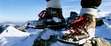 A winter enthusiast conquering a snowy peak wearing Tundra Trek boots.