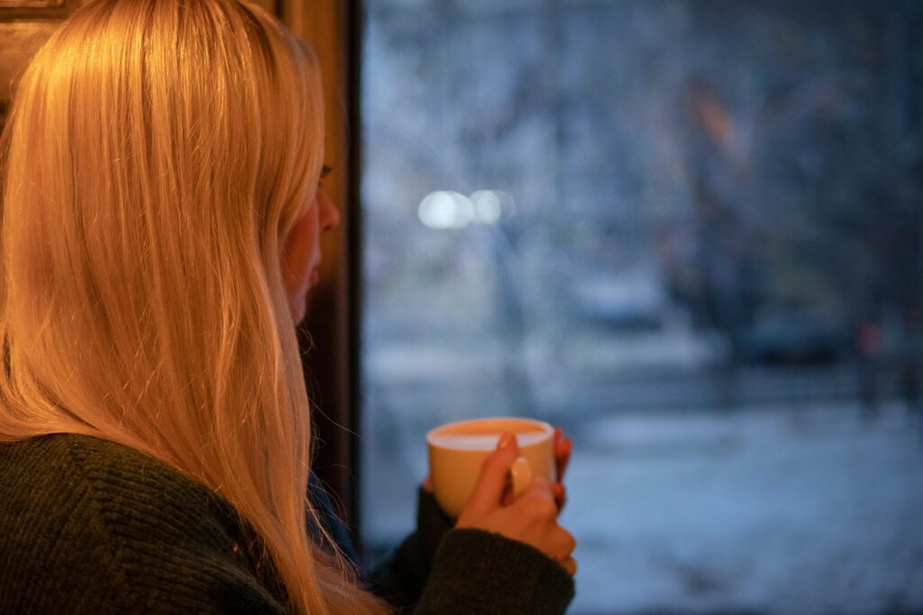 Picture of married woman staring longingly at a GTA winter landscape outside of a window